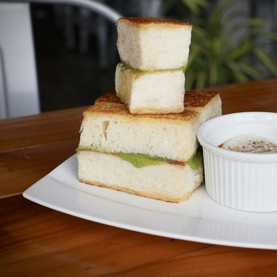 Stacked pandan kaya toast with a soft-boiled egg on the side